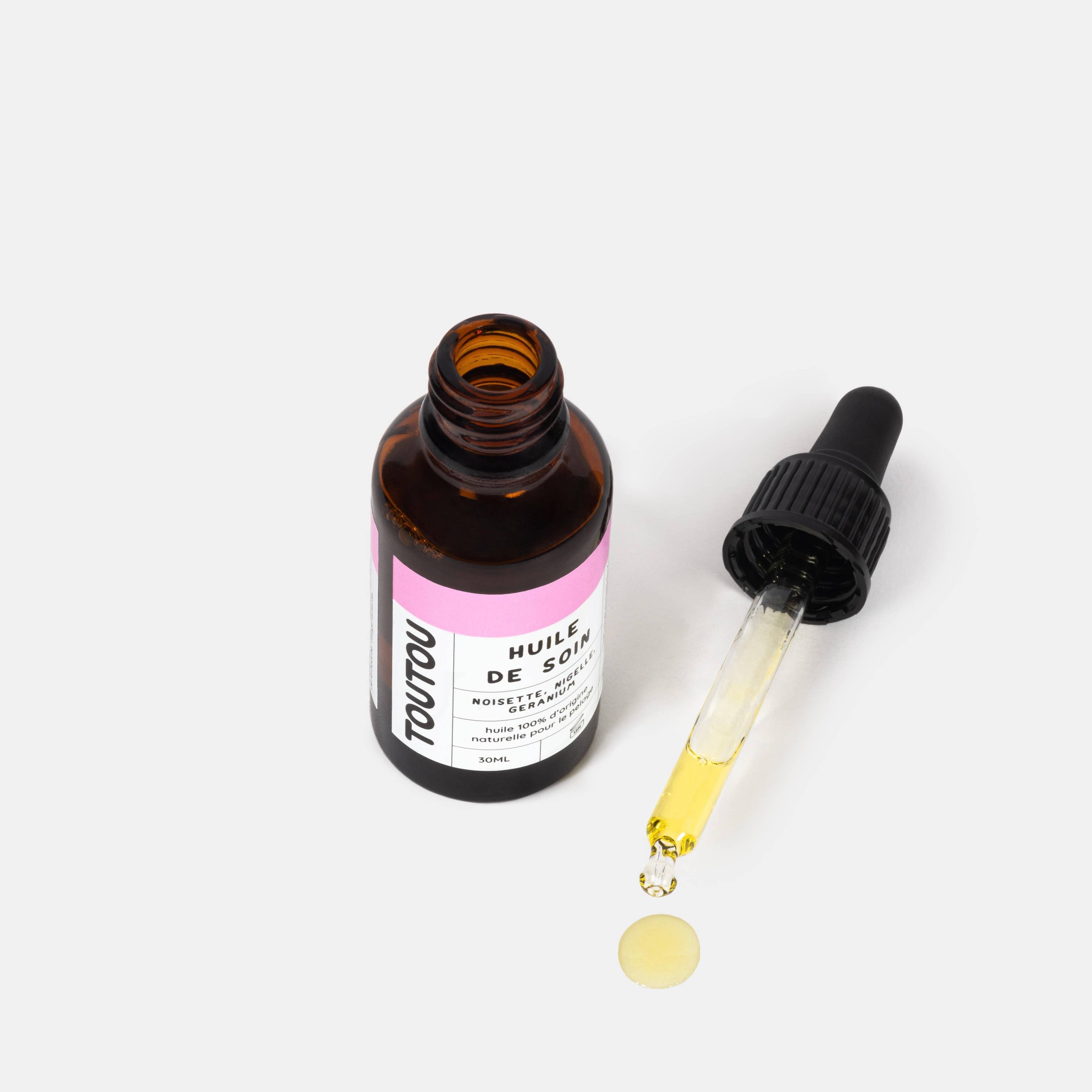 Brown glass bottle with dropper and pink label on a white background